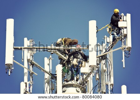 Crew installing antennas on the top of 150' water tower Royalty-Free Stock Photo #80084080