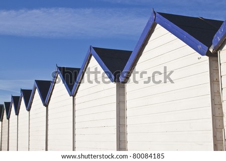 rows of wooden white and blue beach huts