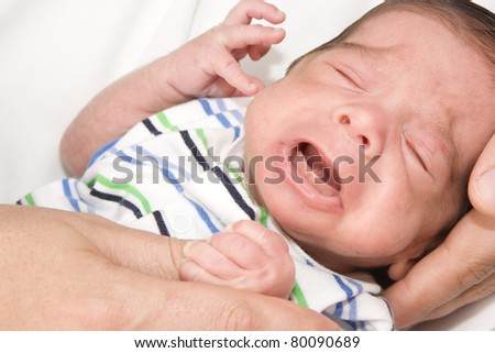 Portrait of Newborn crying on arms at home