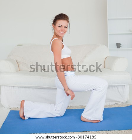 Fit brunette practicing yoga in her living room