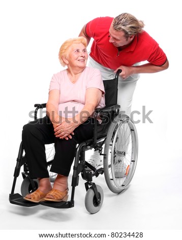 Happy elderly paraplegic woman sitting in a wheelchair and her male nurse.