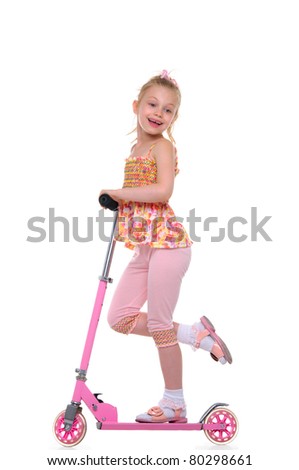 Happy girl riding her scooter isolated on white