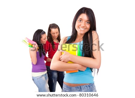 student girl hugging books  with group university students on the background- isolated