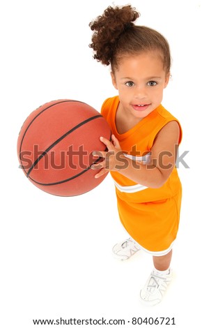 Adorable 3 year old toddler girl child in team uniform holding basketball over white background.