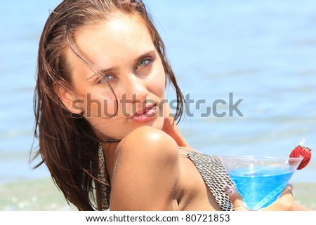 young woman on the beach with cocktail in Greece