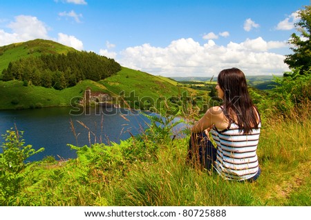 woman looking over Llyn Clywedog Reservoir in Wales UK
