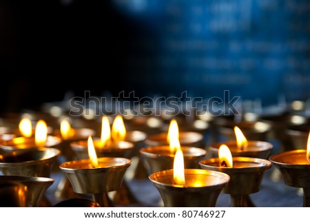 Burning candles in sconces on black blue background