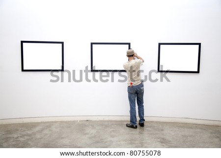 a Museum worker arranging frames on the wall