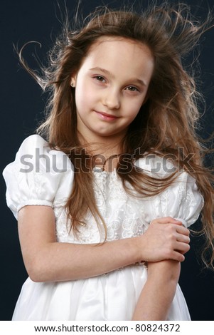Portrait of a happy young girl in studio on dark blue background