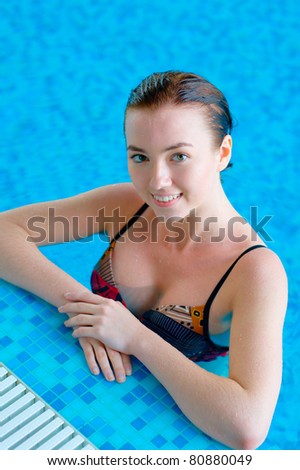 Smiling teen girl in a swimming pool with copy space