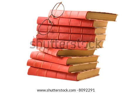 A pile of old red books and glasses on white background