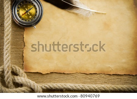parchment paper and feather with rope on wood