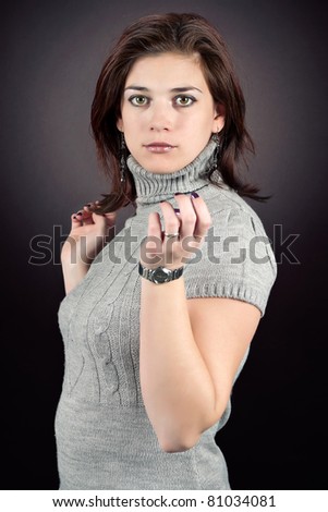 Brunette woman in gray dress posing in studio