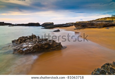 Beautiful panoramic view of secluded beach in Asturias, Spain at sunset