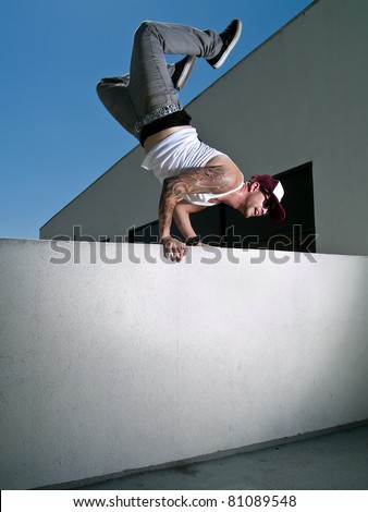 tattooed male parkour free runner doing a hand stand Royalty-Free Stock Photo #81089548