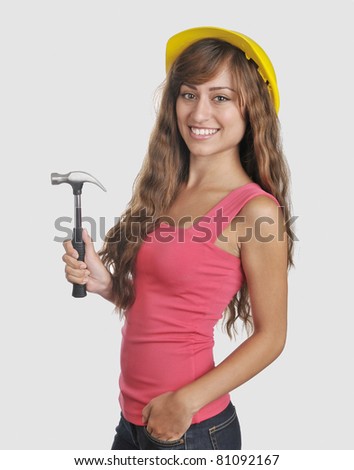 Attractive hispanic female worker/Young Hispanic Construction Worker/Woman wearing hard hat and holding hammer