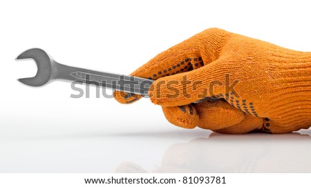 Gloved hand holding the wrench. Isolated on white