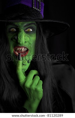 A green wicked witch, dark background.
