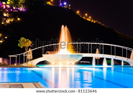 Water pool and fountain at night - vacation background