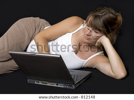 Pregnant woman lying down surfing the web on a laptop