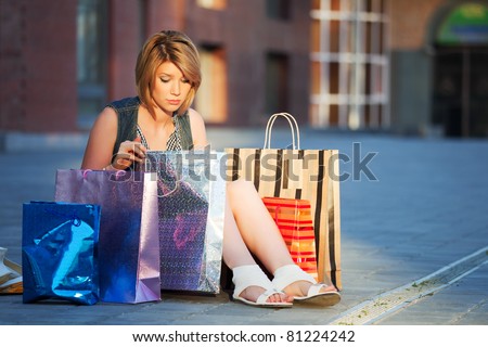 Tired shopper sitting on the sidewalk