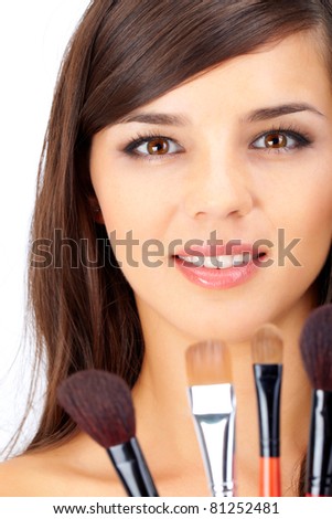 Portrait of a beautiful woman with several brushes