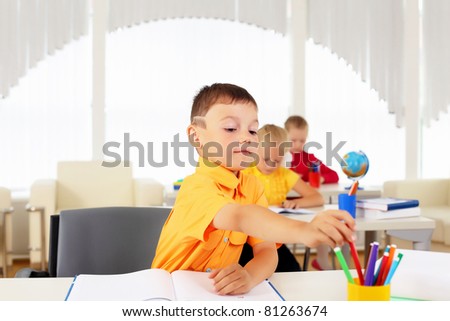 Portrait of a young boy sitting at his desk at school