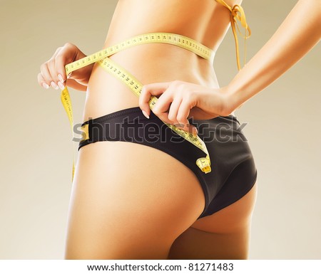 slimming woman in panties with yellow measure
