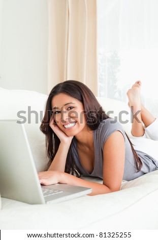 woman lying on sofa looking into camera in living room