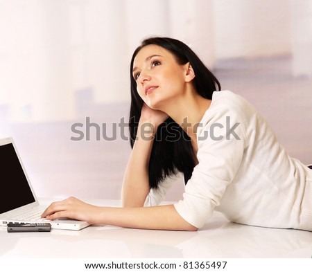 A portrait of looking up woman with a laptop indoors