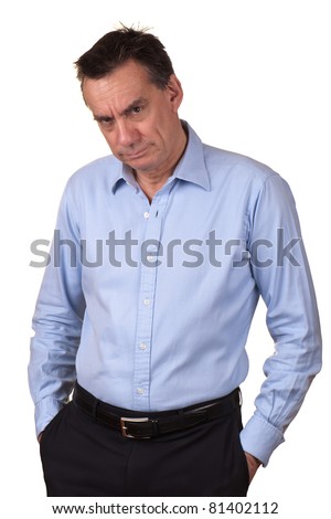 Angry Middle Age Man in Blue Shirt with Grumpy Expression and Hands in Pockets Royalty-Free Stock Photo #81402112