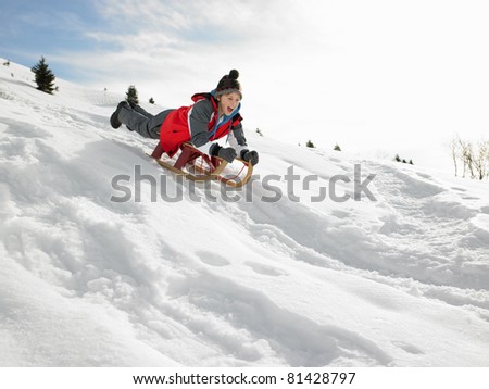Pre-teen Boy On A Sled In The Snow