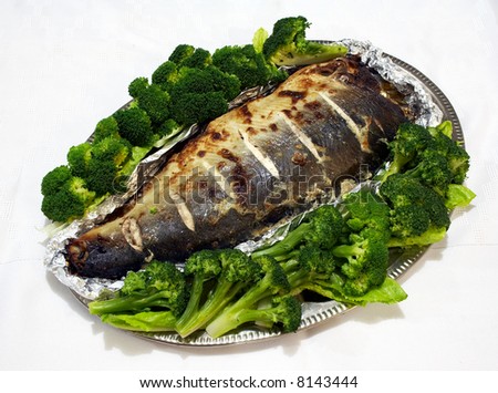 Baked pink salmon served with broccoli on a white tablecloth