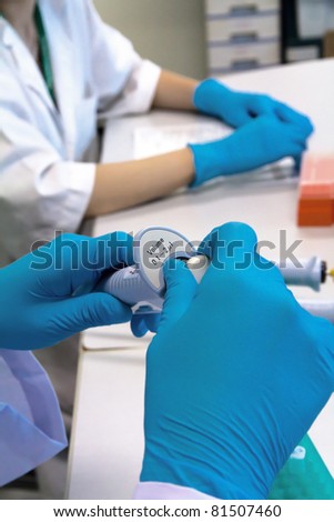  researcher holding pipette in a science research lab