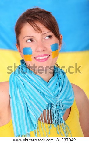 A picture of a happy Ukrainian girl standing against the flag