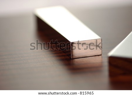A silver bar sits in the middle of the frame with the corner of another in the front with very shallow depth of field Royalty-Free Stock Photo #815965