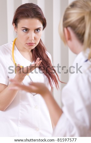 two young stressed doctors discussing something