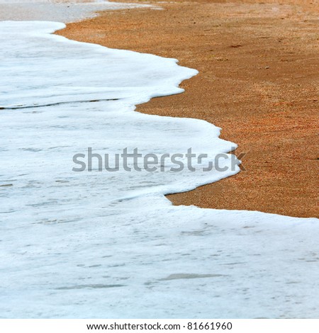 Sea surf foam on coastline sand