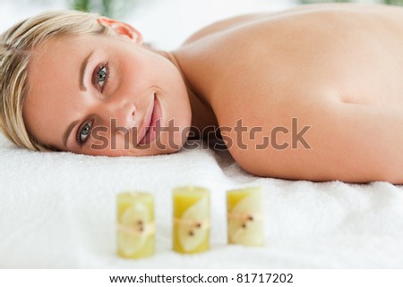 Blonde smiling woman lying on massage lounger in a wellness center
