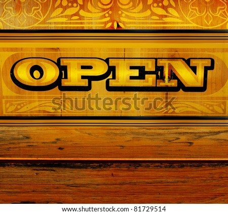 Antique sign with word "OPEN" engraved in old wood with a golden tone
