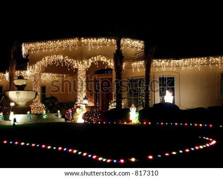 Fountain and Christmas lit house including lights defining driveway.