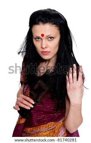 A beautiful brunette in the Indian sari combs comb hair posing in studio on white background