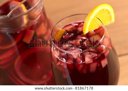 Sangria mixed with orange, apple, mango pieces served in wine glass garnished with orange slice on the rim (Selective Focus, Focus on the front of the orange slice garnish inside the glass) Royalty-Free Stock Photo #81867178
