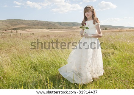girl wearing first communion dress in the meadow