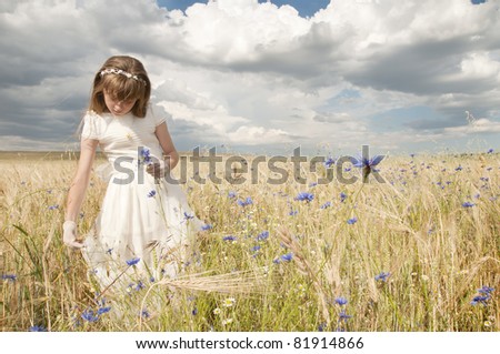 girl wearing first communion dress among the flowers