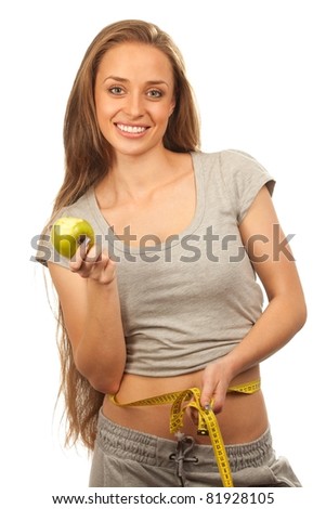Closeup portrait of a charming woman with apple and measuring  her waist over white background