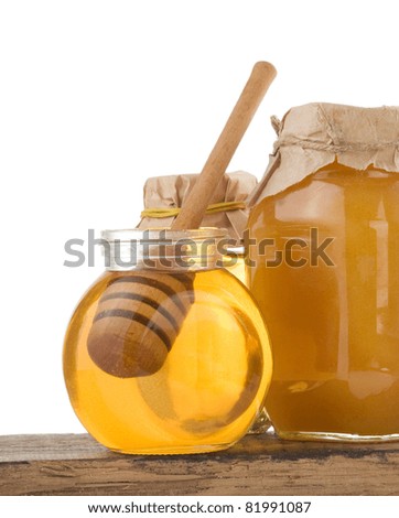 jar of honey and stick isolated on white background