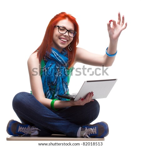 happy girl sitting with laptop over white