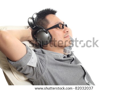 Man relaxing on the sofa and listening to music. Isolated on white background.