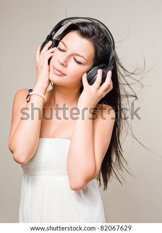 Gorgeous young brunette immersed in music wearing headphones.